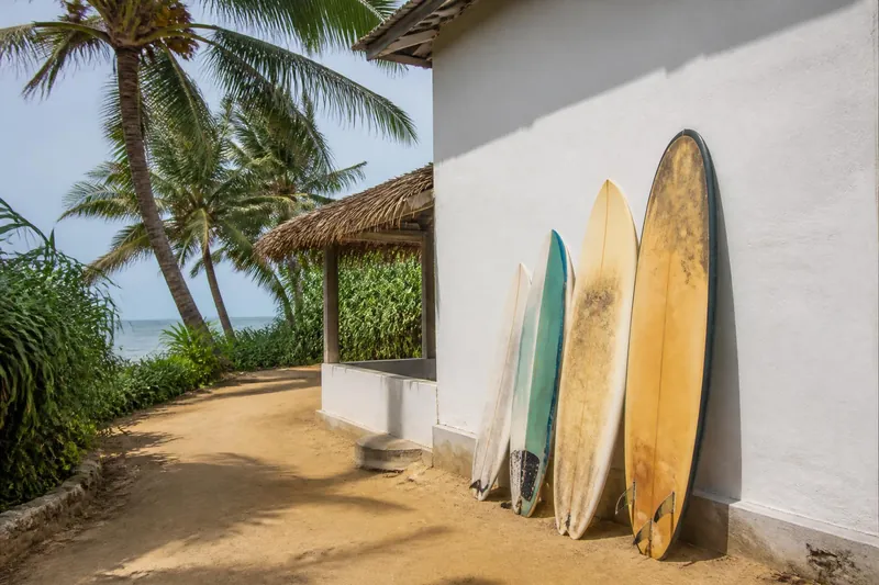 Surfplanken tegen de witte muur van een guesthouse aan de zuidkust van Sri Lanka